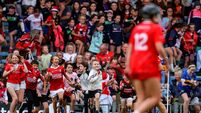 Young Cork fans run onto the pitch after the match 25/7/2026