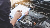 Services car engine machine concept, Automobile mechanic repairman checking a car engine with inspecting writing to the clipboar