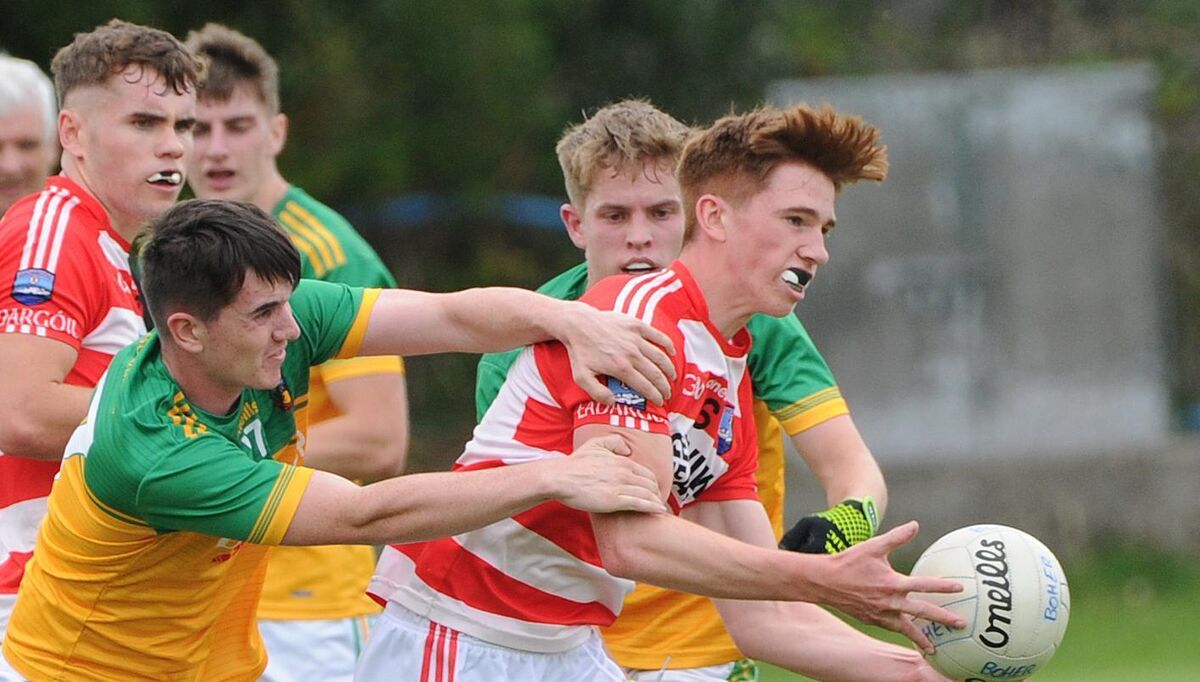 Adrigole's Seán O'Shea hand-passing the ball as he is challenged by Boherbue's Dan Sheehan. Picture: Denis Minihane Adrigole's Seán O'Shea hand-passing the ball as he is challenged by Boherbue's Dan Sheehan. Picture: Denis Minihane