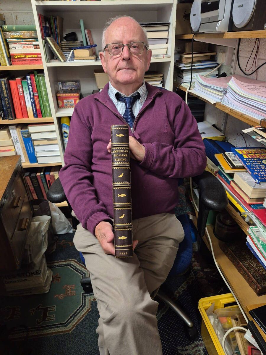 Jim Cooney with one of his rare books in his bookshop in Macroom