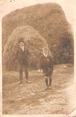 Two youths standing in front of a wynd of hay at the haggard at John's home in 1910. Two youths standing in front of a wynd of hay at the haggard at John's home in 1910.