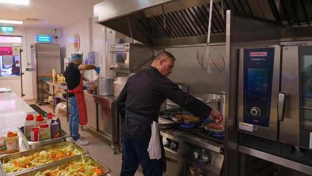 <p>Volunteers cooking food and prepping meals in the kitchen facilities at Cork Penny Dinners. </p>