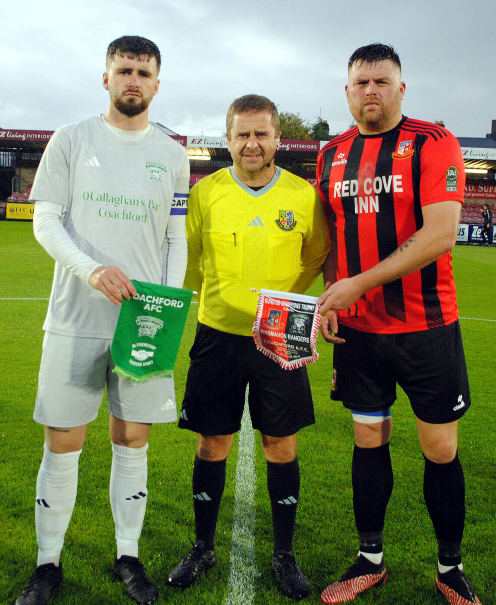 Coachford's Mark Murphy exchanges pennants with Ringmahon Rangers' Alan Higgins, watched by referee Allan Martin.