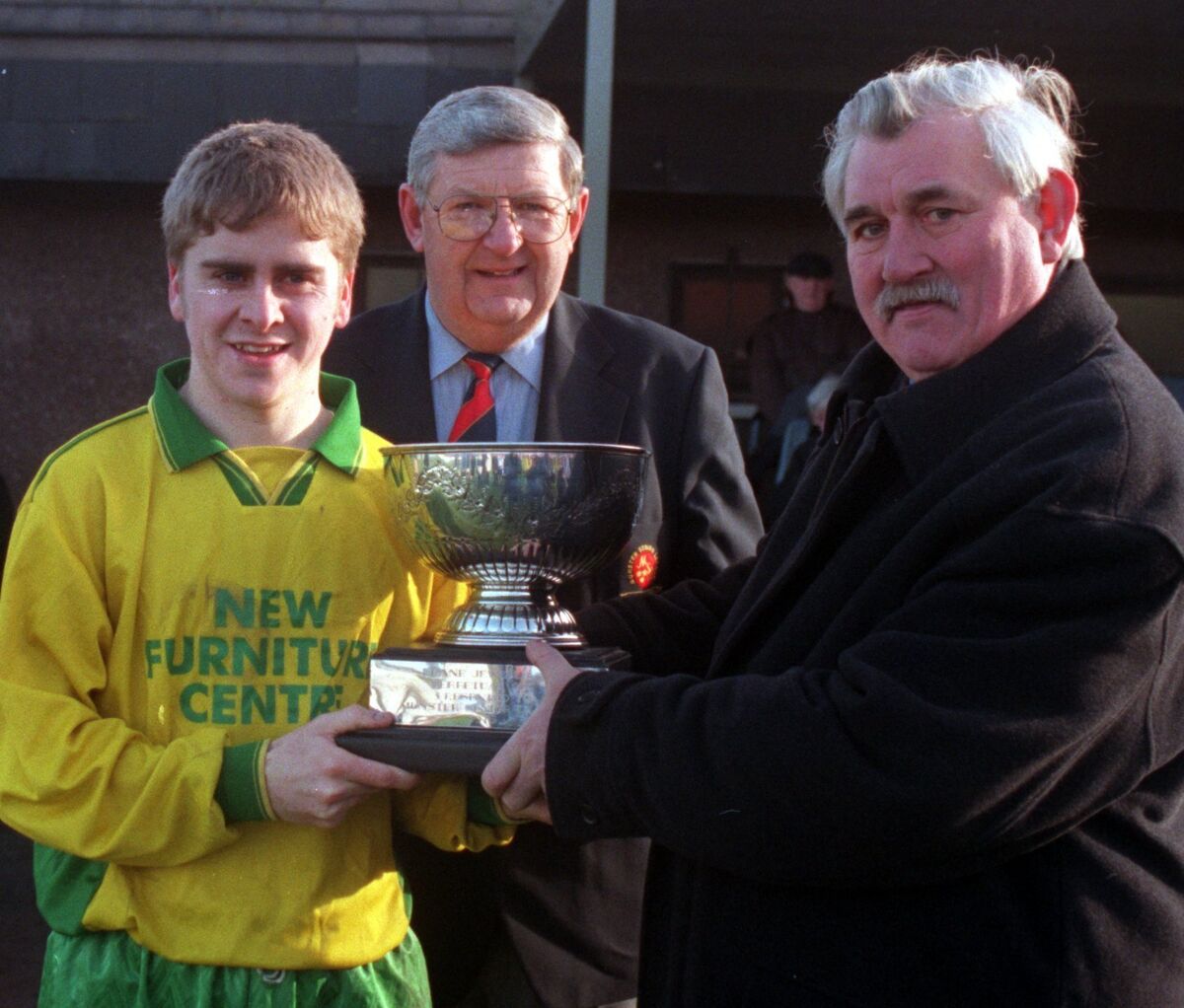 John Smith, Keane's, presents the Keane cup to Allan Martin, captain Rockmount, who defeated Temple United, with Jim Murphy MSL at Turner's Cross. 