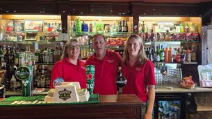 <p>Denis and Tina Murray with daughter Jane behind the bar at Murray’s on Macroom’s main street</p>
