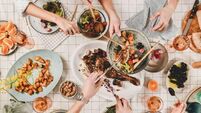 Peoples hands with various snacks and blooming mimosa, top view