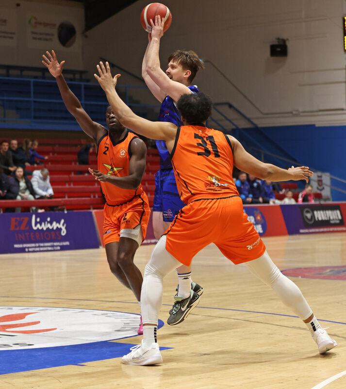  Roy Downey, Energywise Neptune, shoots from Jonathan Brown and Rob Montgomery, Sligo All Stars, in a 2025 game. Picture: Jim Coughlan.