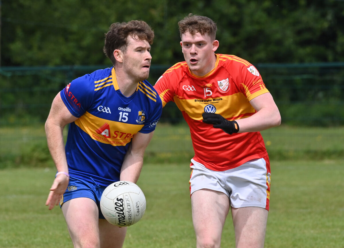 Éanna Desmond of Carrigaline getting his pass away watched by Hugh Murphy of Éire Óg. Picture: Dan Linehan