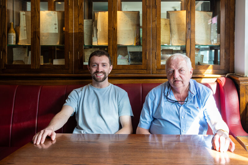 John Cotter and his father Jack Cotter at one of the tables in their bar, TP Cotter’s in Macroom.