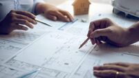 Engineering man showing blueprint detail for people buying house.