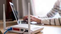 Selective focus at router. Internet router on working table with blurred man connect the cable at the background. Fast and high