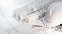 Hard hat and compass on architectural blueprints and construction technology and future industry