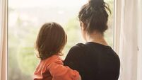 iStock-1130186653.jpg Mother and son looking out of window