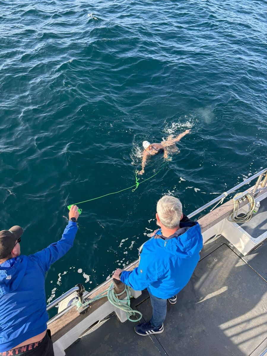 Crew members throwing liquid carbohydrates to Olga during the swim. Crew members throwing liquid carbohydrates to Olga during the swim.