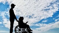 A disabled girl in a wheelchair and her dad on a walk reading a book