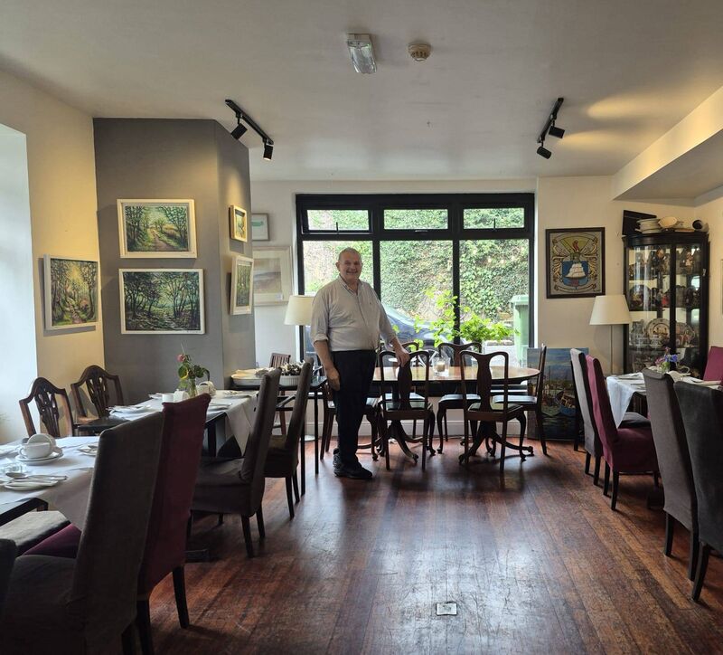 Joe Creedon in the dining room at Creedon’s Hotel in Inchigeelagh, with work by artists currently on show. Joe’s grandfather bought the place when he returned from mining in Montana in 1941