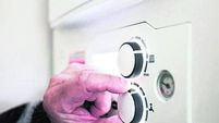 A pensioner adjusting the temperature control on his combi boiler. Redcar, UK. 26/5/2021. Photograph: Stuart Boulton.