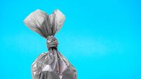 Close up plastic bag gathering with dog poop droppings on a blue background. Eco friendly solution for pet owners