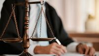 Closeup, scales and law on table, office and attorney man in blurred background with reading for crime analysis. Advocate, lawye