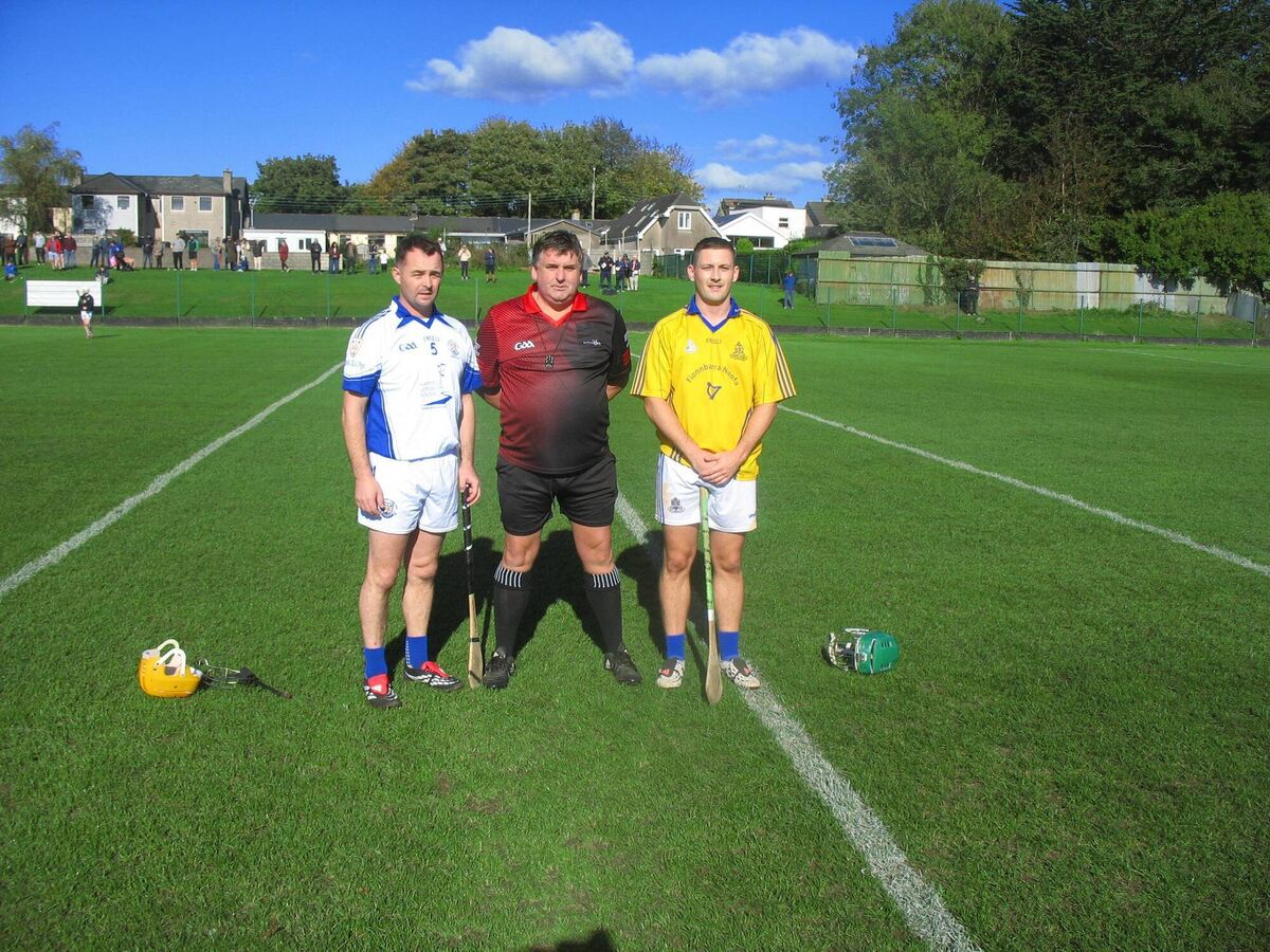 Referee Trevor Lyons accompanied by captains Danny McCormack (Brian Dillon's) and Faolán Linnane (St. Finbarr's) 
