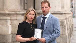 <p>Aine and John Duggan from Sweeneys Hill, Rathpeacon, Co Cork holding a photo of their son George at the court in July. Picture: Collins Courts.</p> <p>Aine and John Duggan from Sweeneys Hill, Rathpeacon, Co Cork holding a photo of their son George at the court in July. Picture: Collins Courts.</p>