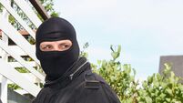 burglar with crowbar and pocket lamp on a ladder on a balcony
