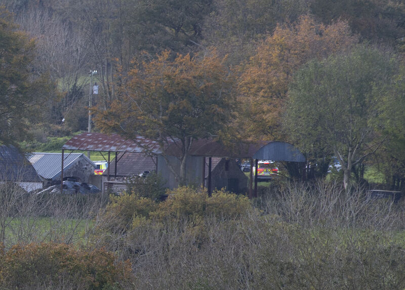  Garda cars parked near out buildings at the farmhouse near Kanturk, Co Cork.