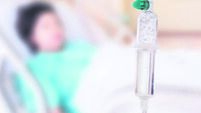 Medical drip with patient in the hospital blurred background