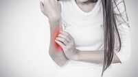 Woman scratching her elbow.