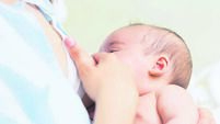 Mother breastfeeding a newborn baby boy