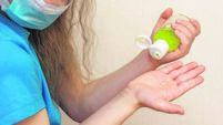 Girlie in the mask pouring sanitising hand gel onto the fingers. Аntibacterial hand cleaning gel. hand alcohol