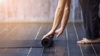Young yogi men rolling mat