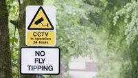 No fly tipping sign in beautiful landscape garden
