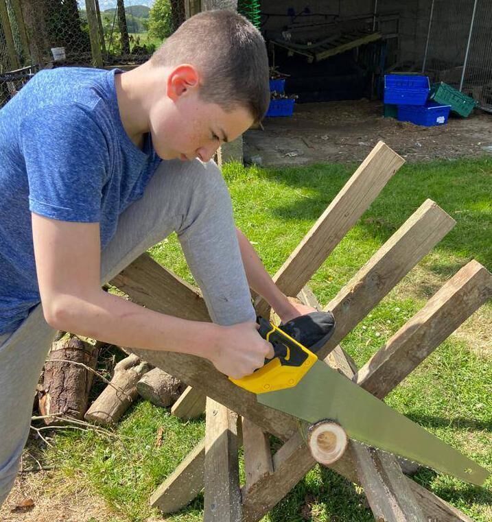 Conor McLoughlin sawing wood to make coasters. Conor McLoughlin sawing wood to make coasters.