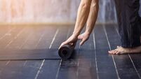Young yogi men rolling mat