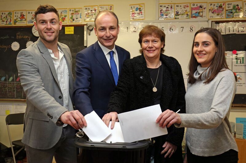 Fianna Fail Leader Micheál Martin, casts his vote during the 2016 General Election with family members son Micheál Aodh, wife Mary, and daughter Aoibhel at St. Anthony's Boys Primary School in Ballinlough