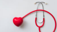 close up red heart and stethoscope on white background,