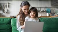 Happy laughing mother and daughter using laptop
