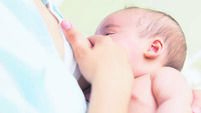 Mother breastfeeding a newborn baby boy
