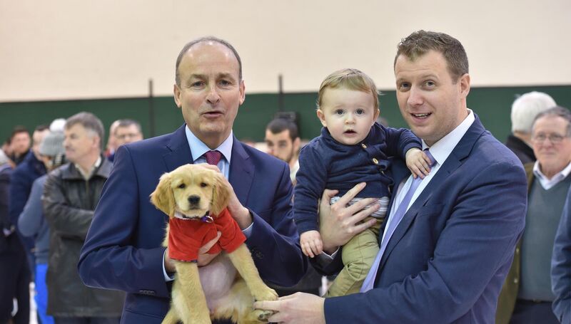 Micheál Martin TD holding Magic the dog with Padrig O’Sullivan and his son Páidí at the count centre at Nemo Rangers GAA club, Cork. Picture Dan Linehan