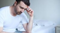 Sad and upset man waking up in the morning light