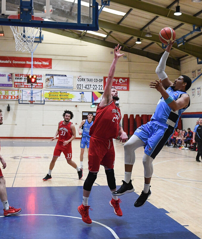 C and S Neptune's Lehmon Colbert shoots under pressure from Templeogue's Jason Killeen. Picture: David Keane.