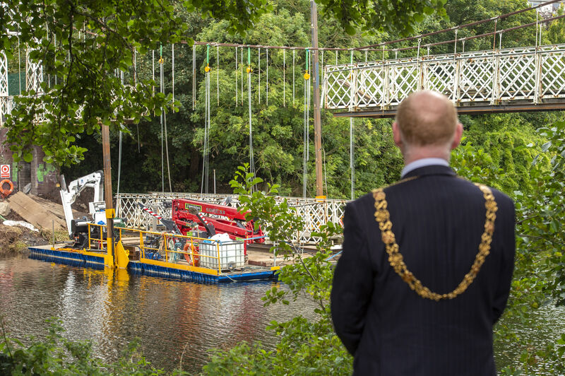 The Lord Mayor of Cork, Cllr. John Sheehan looking on as first section of Daly’s Bridge known locally as the Shakey Bridge is placed on a barge to be taken away for restoration work. Picture Dan Linehan