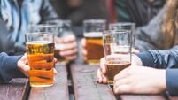 Hands holding glasses with beer on a table in London
