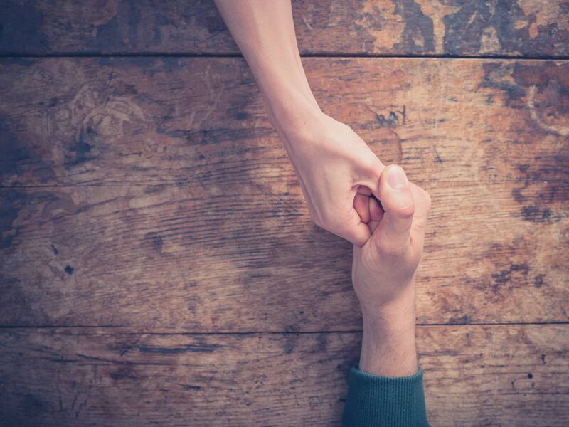 Two people engaged in a game of thumb wars. Two people engaged in a game of thumb wars.