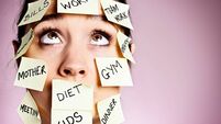Frustrated woman covered in stiocky reminders rolls her eyes