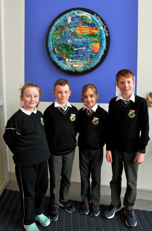 Rang 4 pupils (from left) Ciara Ní Riain D'Ardis, Ríain Mac Cormaic, Aoibhín de Paor agus Jack Ó Broin, who took part in a workshop on plastic in the oceans, standing beneath a piece of art, Our Plastic Planet, by Grace Hamilton.Picture Denis Minihane.