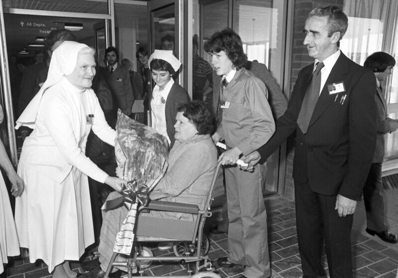 FIRST PATIENT: Opening day of Cork Regional Hospital, November 30, 1978: Sr M. Thecla, matron, greets Emily Curran the hospital’s first patient, assisted by Tony Fitzgerald, wheelchair attendant and later Cork City Lord Mayor; nurse Mary Owens; and Michael Cogan, head porter.	 Ref: 223/075 223/75