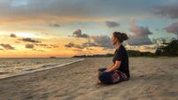 Woman relaxing on beach at sunset
