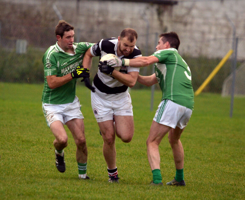 St Nick’s Dean Brosnan holding off the tackle Jerry McCarthy and Niall Hurley for Dohenys. Picture: Denis Boyle